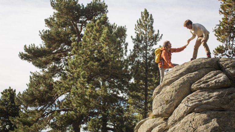 hikers climbing cliff