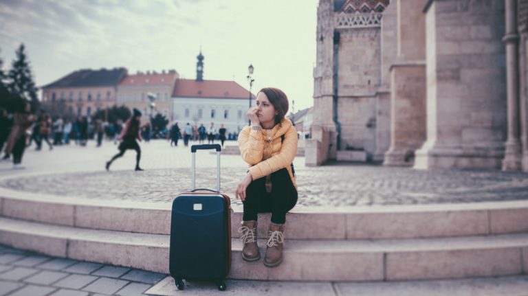 woman with suitcase on steps