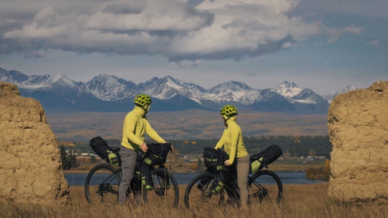 Two cyclists overlooking mountain landscape