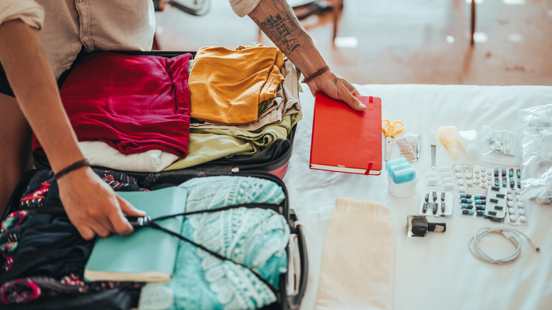 Traveler packing a suitcase