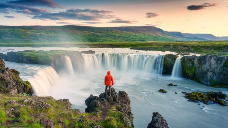 Hiker overlooking Godafoss waterfall