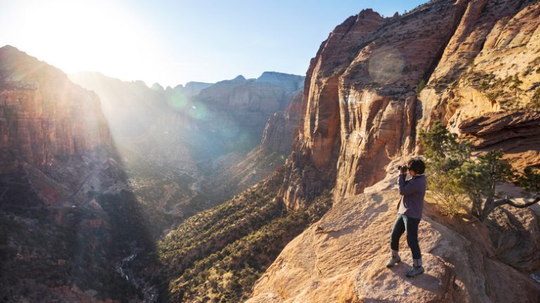 Woman on cliff at sunrise