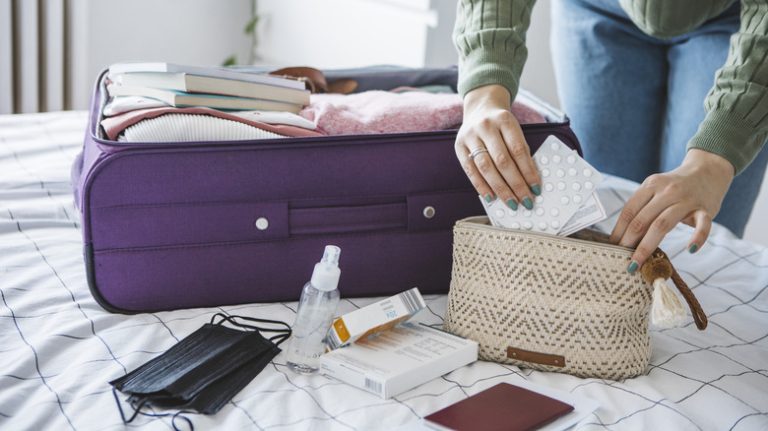 hand putting medication in travel pack