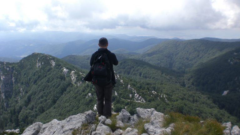 person standing at mountain viewpoint