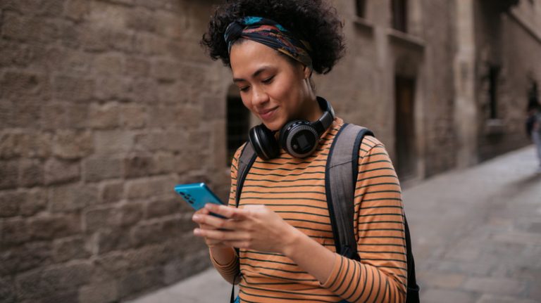 Traveler using cell phone in the street