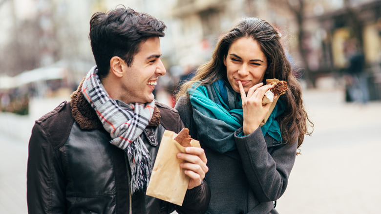 couple eating brownie and laughing