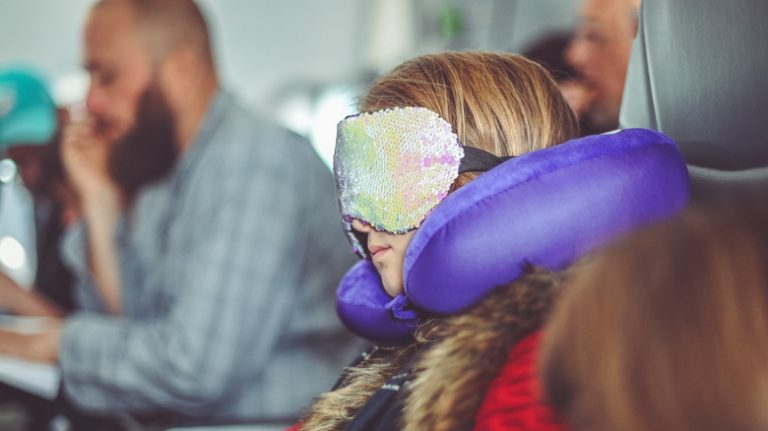 Passenger with eyemask and travel pillow