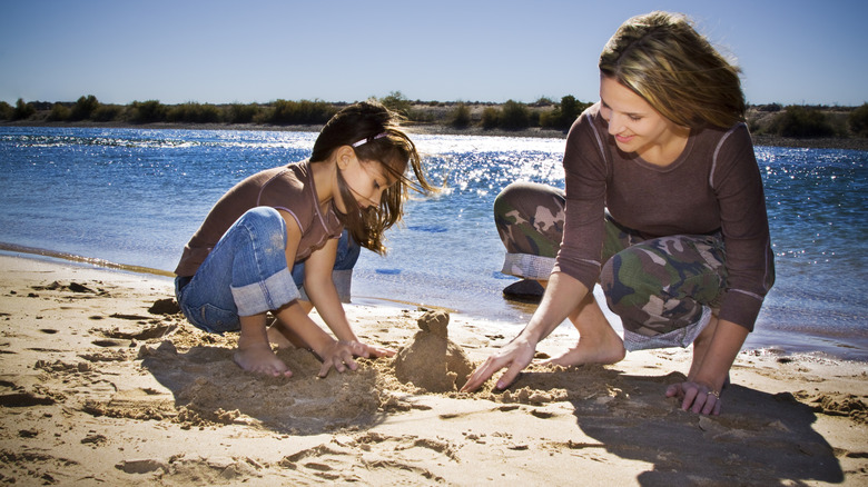 mother daughter sandcastle river beach