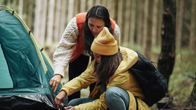 Two women setting up a tent