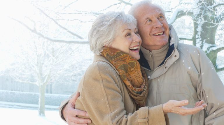 Elderly couple watching snow fall