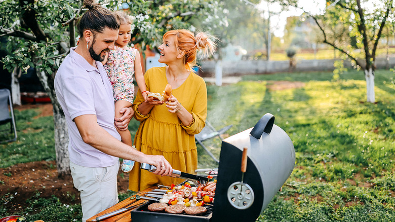 Family barbecuing food on the grill