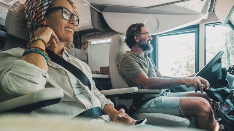 A couple driving an RV