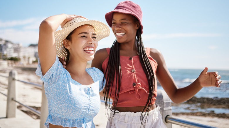 women friends laughing on beach