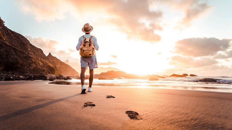 Man wearing backpack on beach