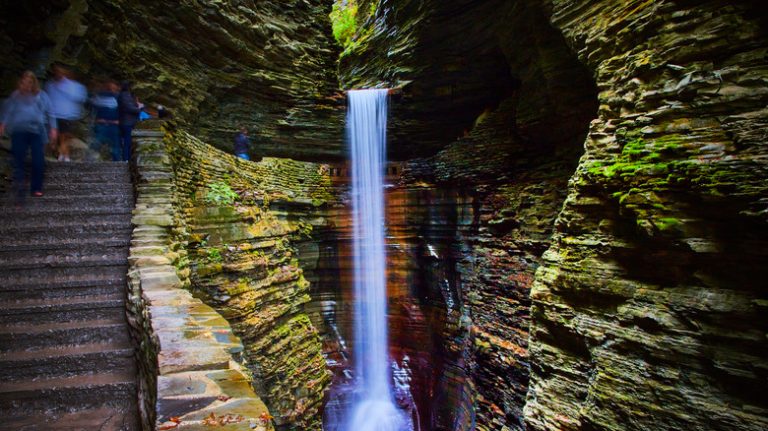 People hiking behind a waterfall