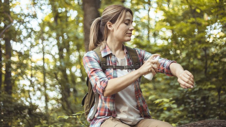 Woman applying bug repellent