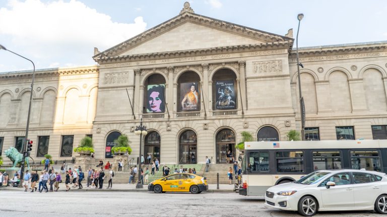 Stone building with cars and crowd