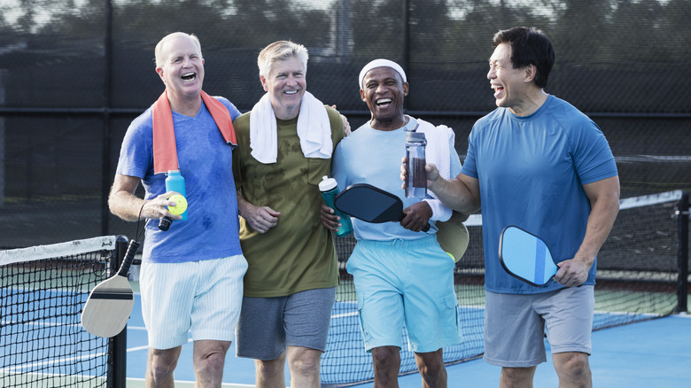 Men laughing on pickleball court