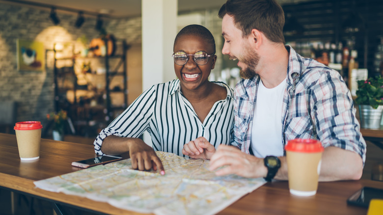 Laughing couple looking at map