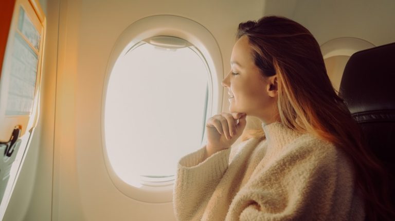 woman looking out plane window