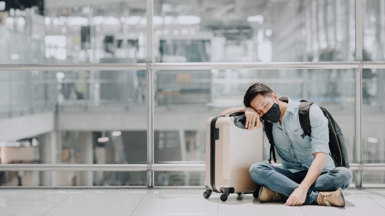 Traveler sleeping on their suitcase