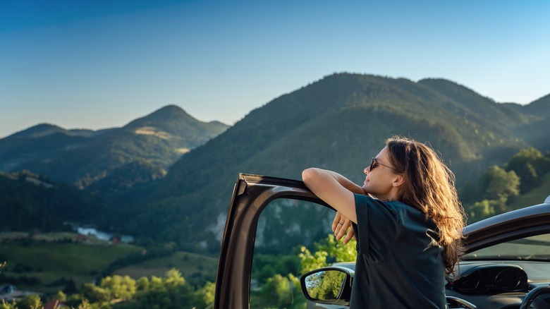 woman resting on car door