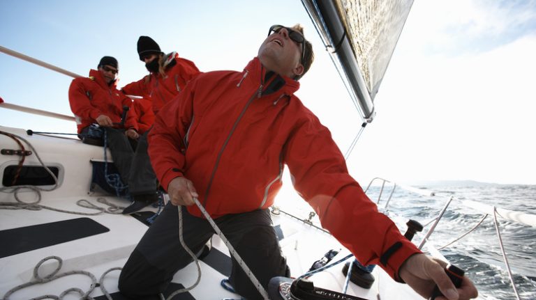 three people sailing boat