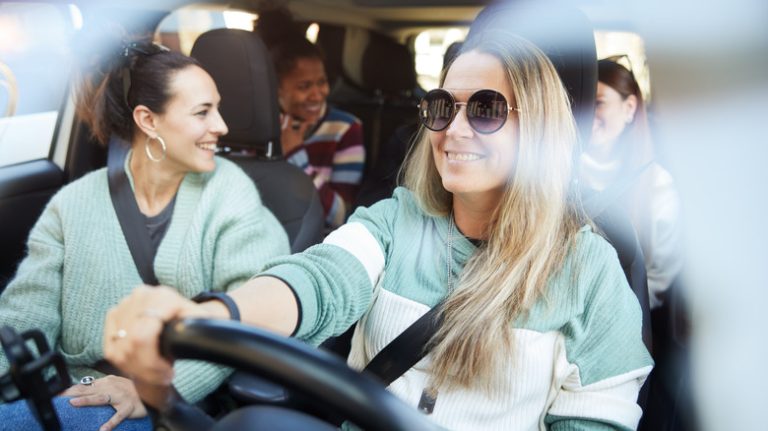 Friends riding in a car, smiling