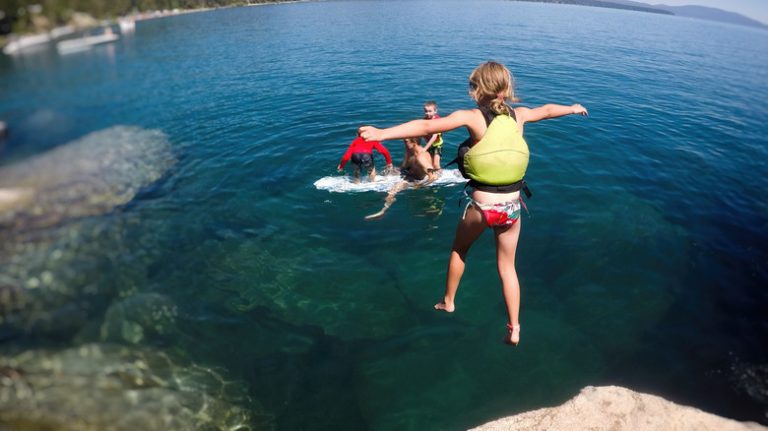 Girl jumping into lake