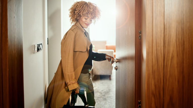 woman smiles entering hotel room