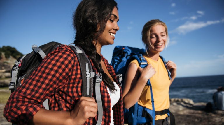 women hiking along water