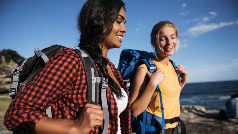 women hiking along water