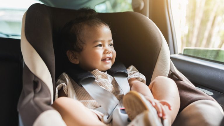 Smiling baby in car seat