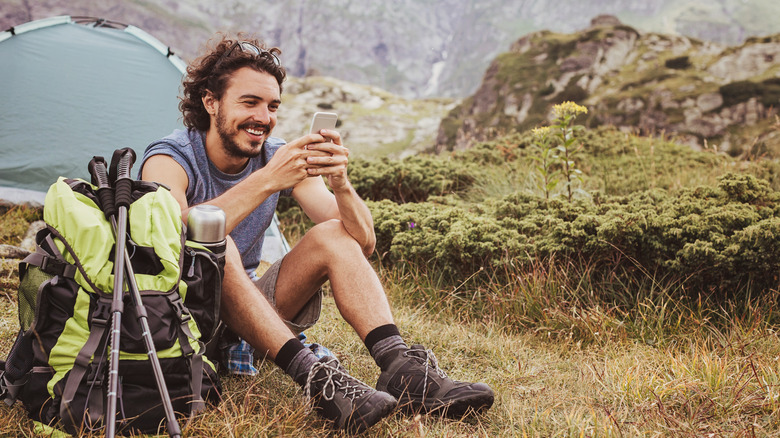 Backpacker using their phone