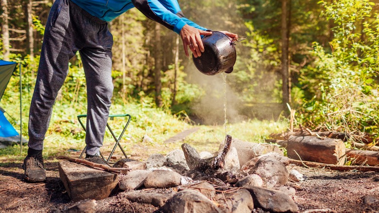 Man putting out campfire