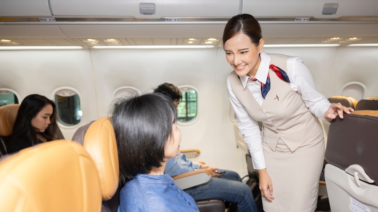 flight attendant helping passenger