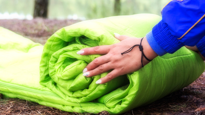 woman folding out sleeping bag