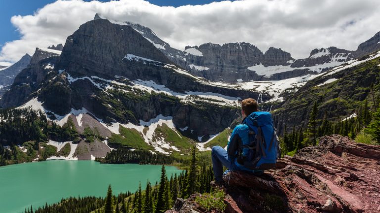 Mountain hiker sitting on cliff