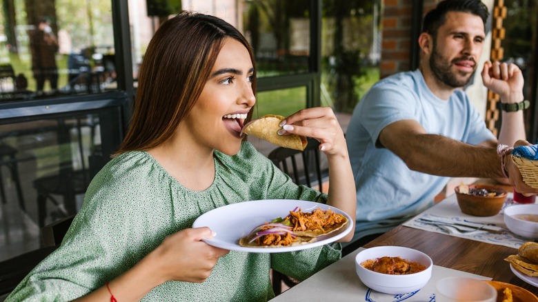 Woman eating a taco at a restaurant