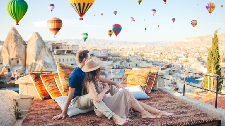 Couple on rooftop watching balloons