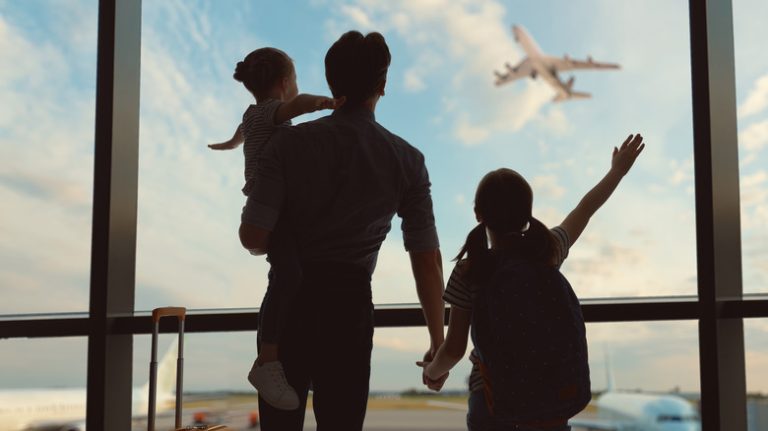 Family silhouetted against airport window