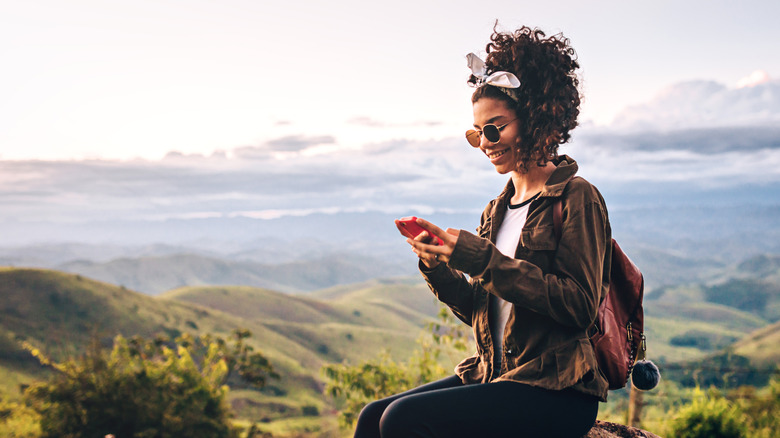 woman sitting outside with phone