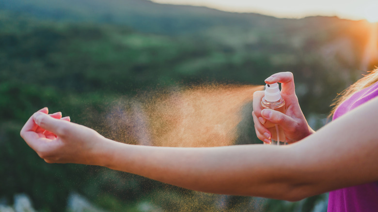 Woman spraying bug repellant