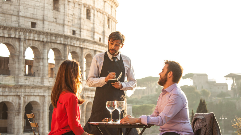 Waiter serving couple, Rome, Italy