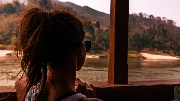 Woman looking over boat balcony